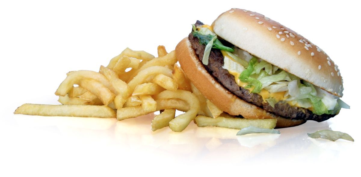 Hamburgare med ost och sallad bredvid en portion pommes frites