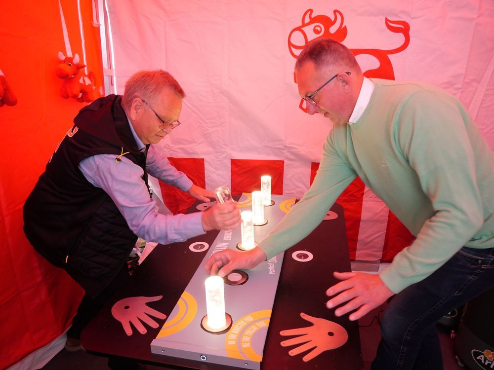Två män spelar ett reaktionsspel i ett rött tält.